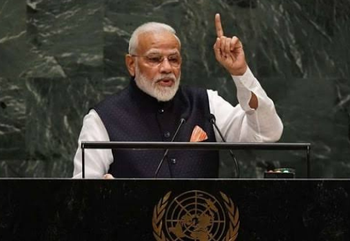 Prime Minister Narendra Modi addressing the UN General Assembly. He is standing on a podium with a finger raised in the air.